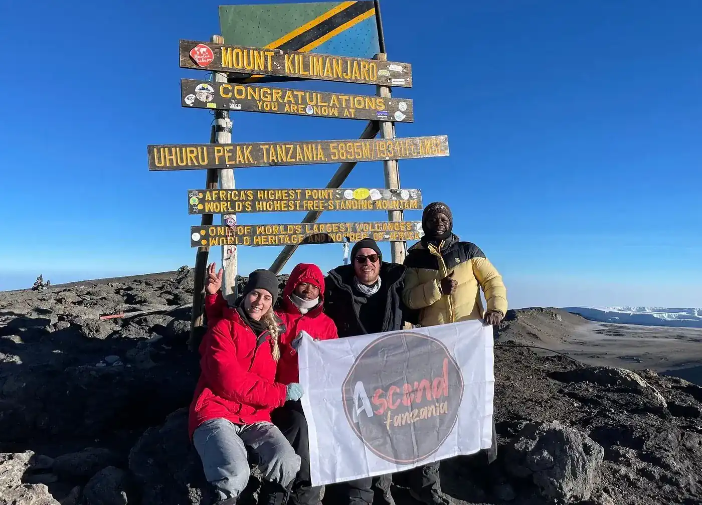 Climbers ascending the final volcanic crater rim at sunrise on Kilimanjaro summit morning